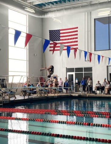 A swimmer flips off the diveboard during leagues