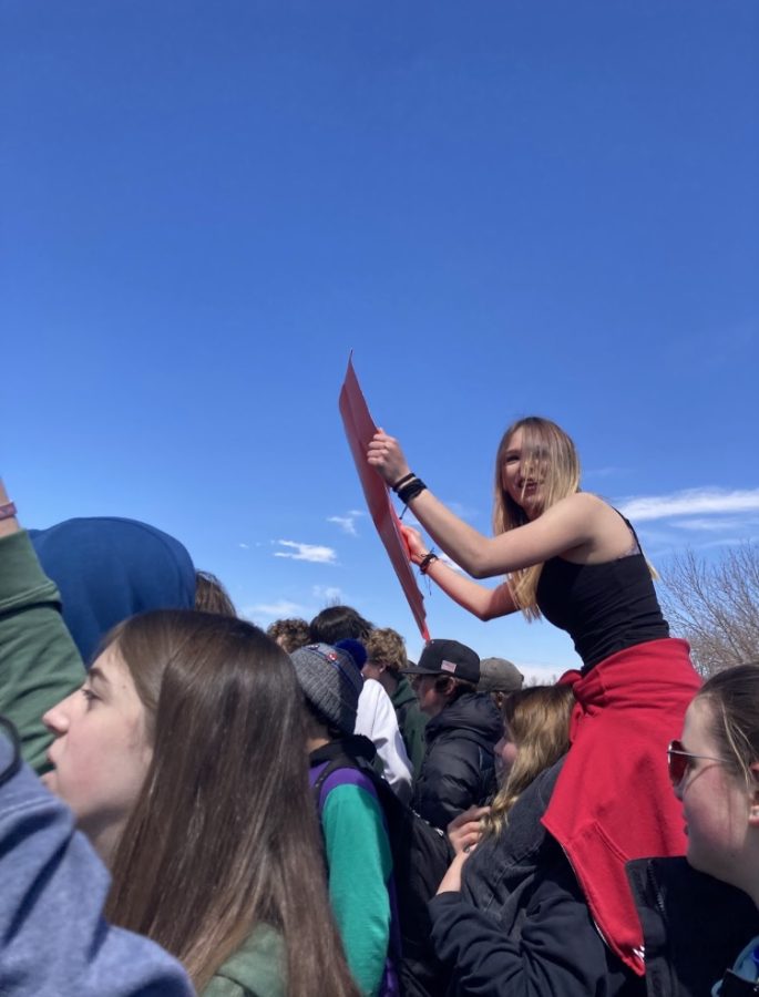 A student rides on their friends shoulders during the walkout.