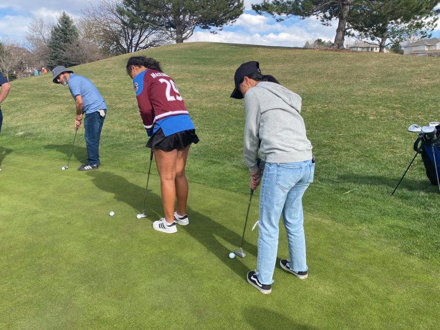 Teammates practice for an upcoming golf tournament