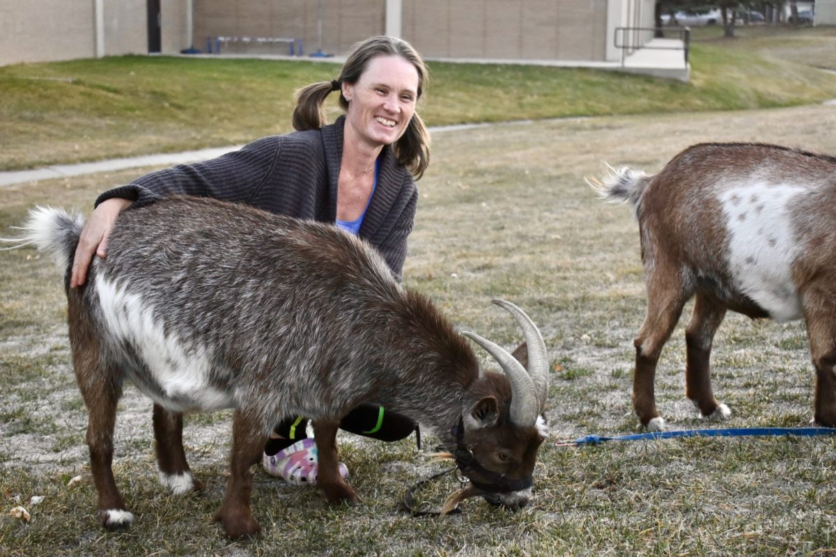 Florence Boski smiles while petting her two goats, Midnight and Coco.