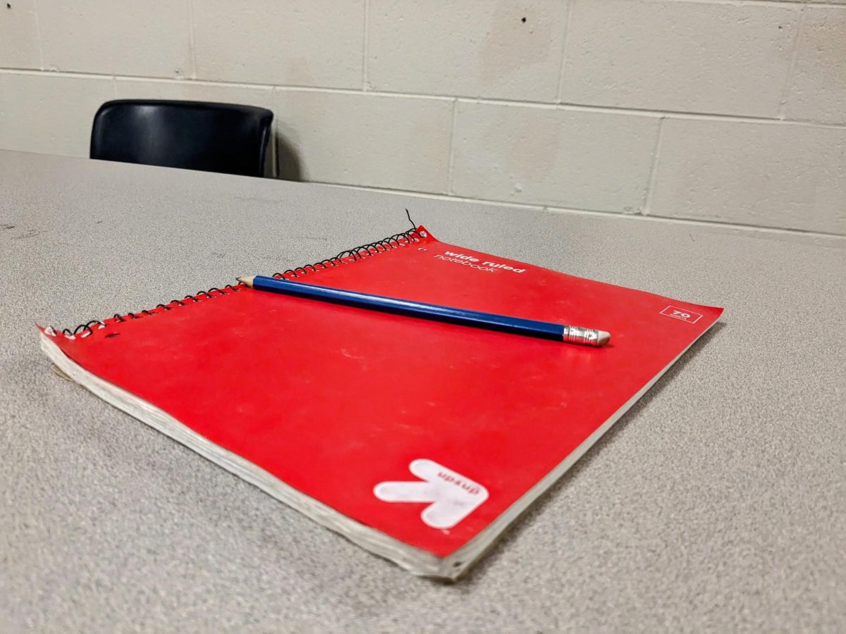 A Red Notebook and Pencil on a Table
