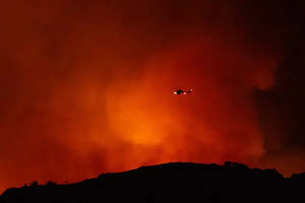 A helicopter flying over the Palisades Fire in California - The New York Times