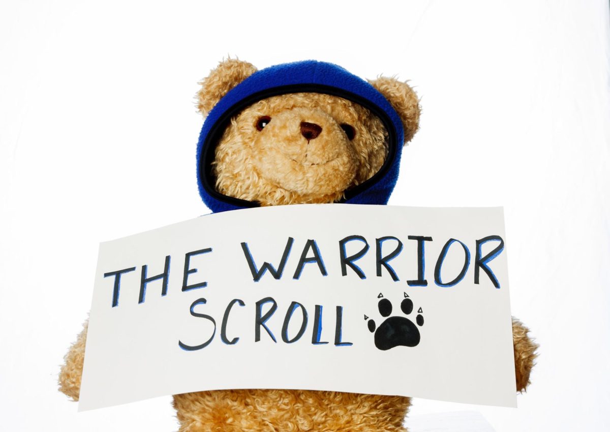 Reggie holds up a sign that reads "The Warrior Scroll"